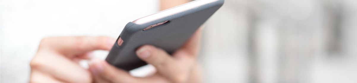 Close-up of a person holding and using a smartphone with a black case